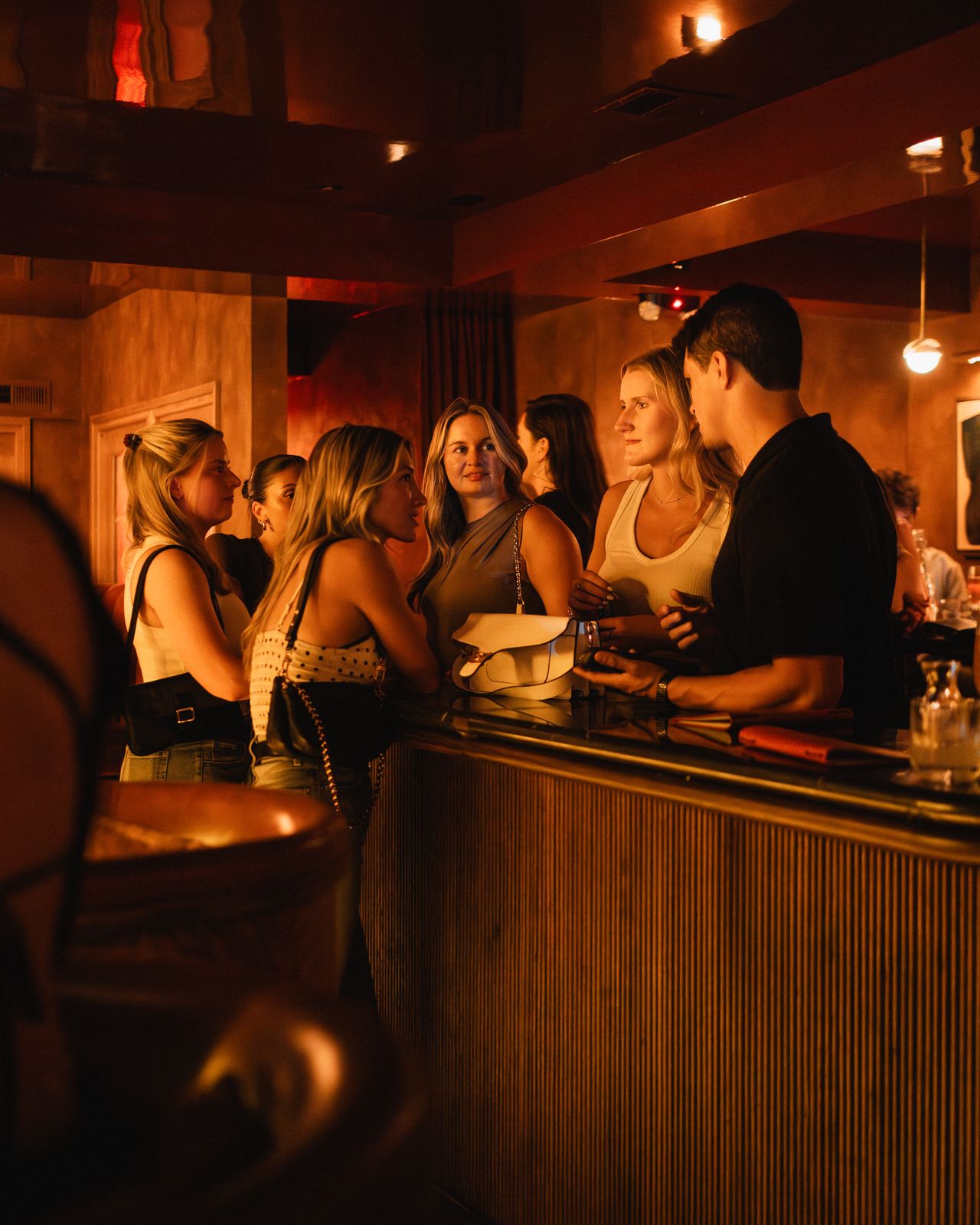 Friends gathered chatting around the bar counter