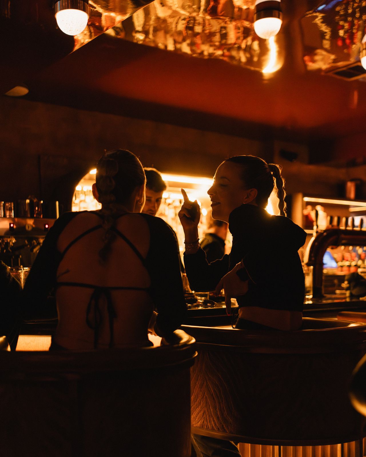 Silhouetted pair sharing a laugh at the bar
